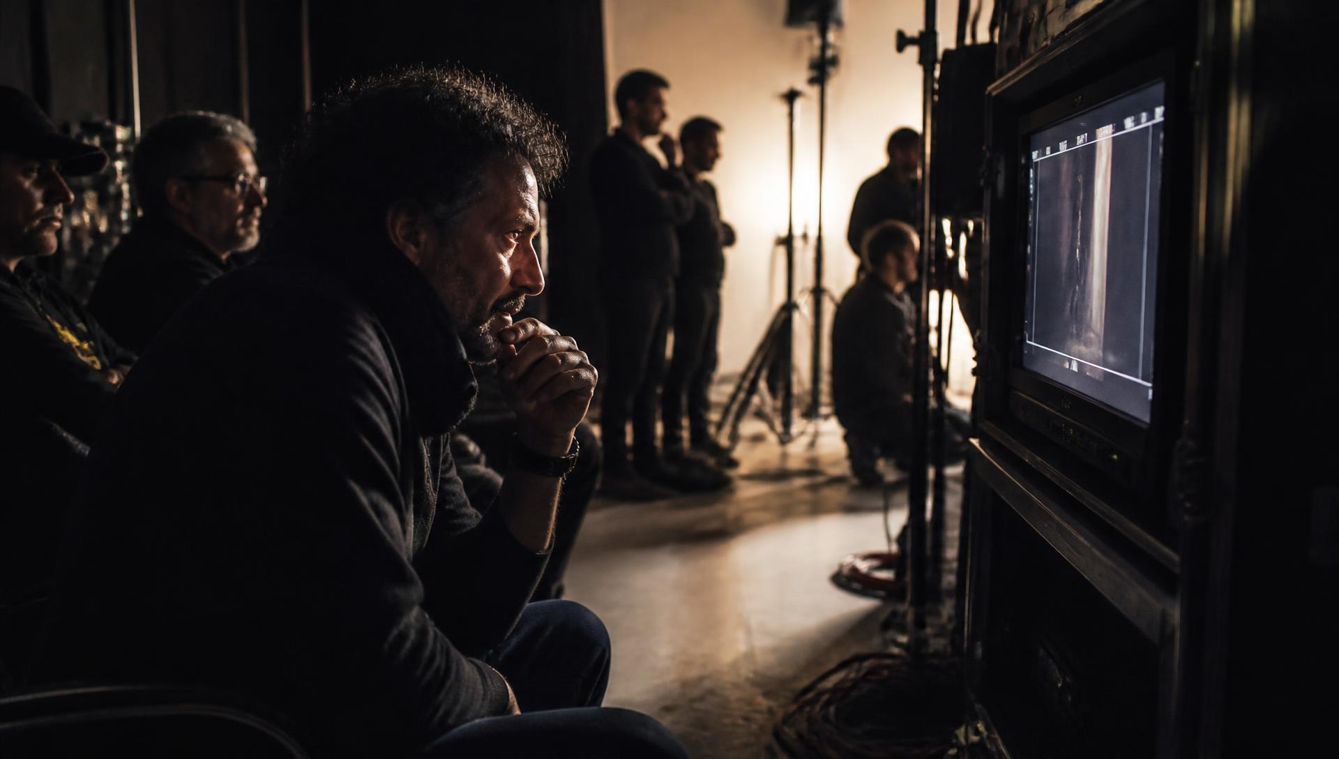 Director watching a production monitor on a dark film set
